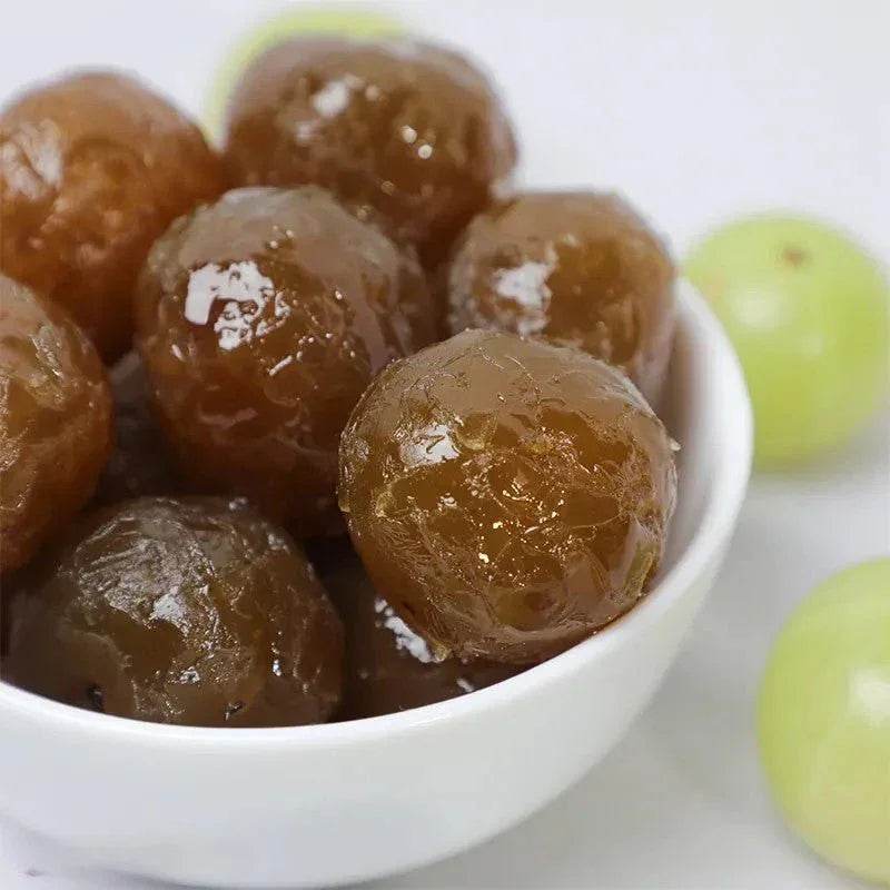 White bowl filled with preserved or candied fruits on a white background. BKH Organics Honey Amla