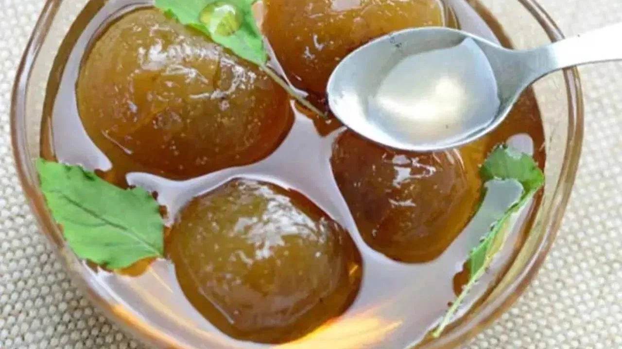 Glass bowl with brown gelatin dessert and a spoon, on a textured surface. BKH