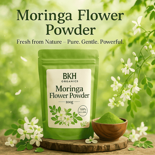 BKH Organics Moringa Flower Powder package with green powder in a wooden bowl, surrounded by flowers and leaves. Murungai Poo Powder 100g - BKH Organics