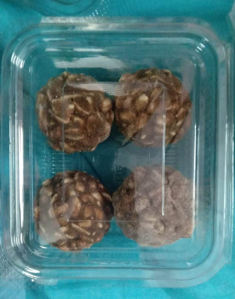 Four chocolate truffles in a clear plastic container on a blue background. Porula Urundai (Millets) 4pcs - BKH Organics