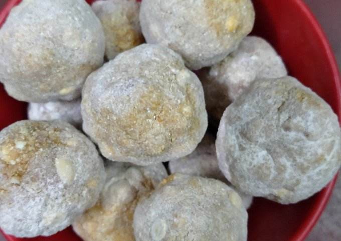 Close-up of snowball cookies in a red bowl. Porula Urundai (Millets) 4pcs - BKH Organics