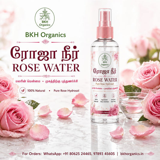 A bottle of BKH Organics Rose Water pure rose hydrosol stands on a marble surface surrounded by pink roses and petals, with promotional text and the BKH Organics logo on a soft pink background.