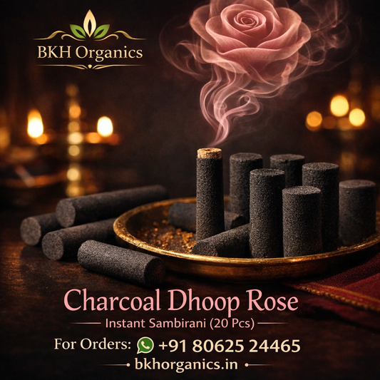 Charcoal Dhoop Rose with BKH Organics branding on a dark background, BKH Organics Charcoal Dhoop Rose Sticks (தமிழ்: ரோஜா தூப் ஸ்டிக்ஸ், తెలుగు: గులాబీ ధూప్ స్టిక్స్, ಕನ್ನಡ: ಗುಲಾಬಿ ಧೂಪ್ ಕಡ್ಡಿಗಳು, മലയാളം: റോസ് ധൂപം / ധൂപ് സ്റ്റിക്കുകൾ, ತುಳು: ರೋಸ್ ಧೂಪ್ದ ಕಡ್ಡಿಕುಲು) lit on a brass holder with fragrant rose smoke and acrylic container box