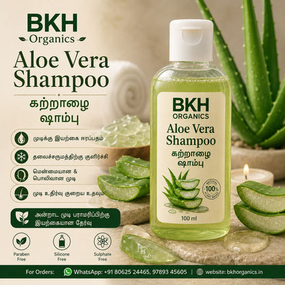 BKH Organics Aloe Vera Shampoo bottle with aloe vera leaves and a candle on a wooden surface.
