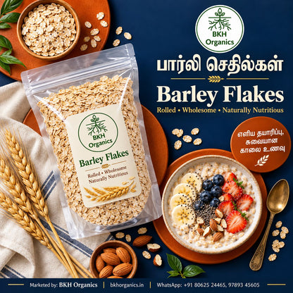 A bag of BKH Organics rolled barley flakes is displayed on a dark blue background with bowls of oatmeal topped with fruit, oats, almonds, and a spoon, plus text in English and Tamil. BKH Organics Rolled Barley Flakes (தமிழ்: பார்லி செதில்கள், తెలుగు: బార్లీ ఫ్లేక్స్, ಕನ್ನಡ: ಬಾರ್ಲಿ ಫ್ಲೇಕ್ಸ್ / ಬಾರ್ಲಿ ಅವಲಕ್ಕಿ, മലയാളം: ബാർലി ഫ്ലേക്സ്, ತುಳು: ಬಾರ್ಲಿ ಫ್ಲೇಕ್ಸ್) pouch with wholesome breakfast porridge bowl topped with strawberries, banana slices, almonds, and honey dripper