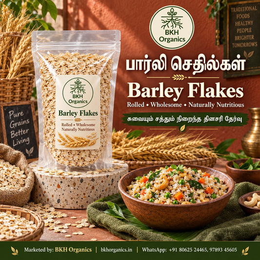 A promotional product image for BKH Organics Barley Flakes. A clear stand-up pouch of rolled barley flakes with a white and green label is shown next to a bowl of oatmeal topped with sliced strawberries, almonds, and honey, with a wooden honey dipper, a jar of honey, and loose grains on a table. BKH Organics Rolled Barley Flakes (தமிழ்: பார்லி செதில்கள், తెలుగు: బార్లీ ఫ్లేక్స్, ಕನ್ನಡ: ಬಾರ್ಲಿ ಫ್ಲೇಕ್ಸ್ / ಬಾರ್ಲಿ ಅವಲಕ್ಕಿ, മലയാളം: ബാർലി ഫ്ലേക്സ്, ತುಳು: ಬಾರ್ಲಿ ಫ್ಲೇಕ್ಸ್) pouch with wholesome breakfast porridge bo