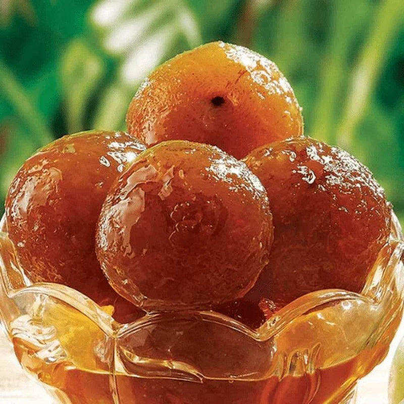 Bowl of sweet dumplings with a green blurred background - BKH Organics. Honey Amla