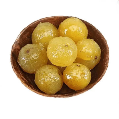 Wooden bowl filled with yellow grapes on a white background