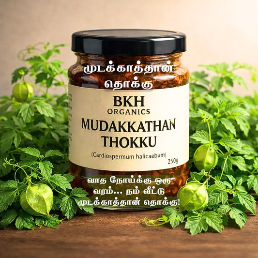 Jar of BKH Organics Mudakkathan Thokku surrounded by green plants on a wooden surface.