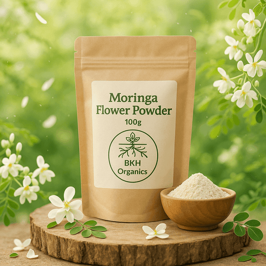 BKH Organics Moringa Flower Powder package with a small bowl of powder on a wooden surface with flowers in the background. Murungai Poo Powder 100g - BKH Organics
