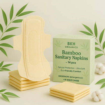 Bamboo sanitary napkins with packaging on a light background with green leaves.