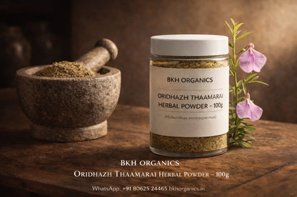 BKH Organics herbal powder jar with mortar and pestle and flowers on a wooden surface