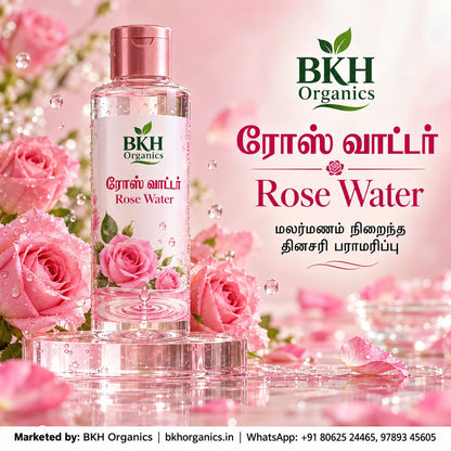 BKH Organics Pure Rose Water (தமிழ்: ரோஸ் வாட்டர் / பன்னீர், తెలుగు: రోజ్ వాటర్ / గులాబీ నీరు, ಕನ್ನಡ: ಗುಲಾಬಿ ನೀರು / ರೋಸ್ ವಾಟರ್, മലയാളം: പനിനീർ / റോസ് വാട്ടർ, ತುಳು: ಗುಲಾಬಿ ನೀರ್) facial mist bottle surrounded by fresh dewy pink roses and water splashes