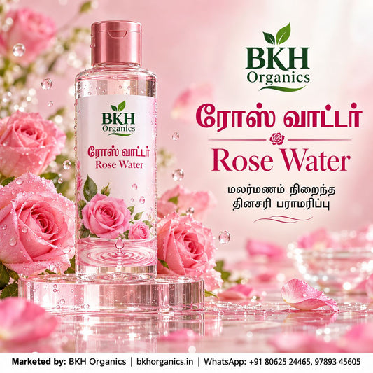 BKH Organics Pure Rose Water (தமிழ்: ரோஸ் வாட்டர் / பன்னீர், తెలుగు: రోజ్ వాటర్ / గులాబీ నీరు, ಕನ್ನಡ: ಗುಲಾಬಿ ನೀರು / ರೋಸ್ ವಾಟರ್, മലയാളം: പനിനീർ / റോസ് വാട്ടർ, ತುಳು: ಗುಲಾಬಿ ನೀರ್) facial mist bottle surrounded by fresh dewy pink roses and water splashes