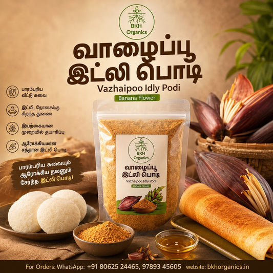 A stand-up pouch of BKH Organics Vazhaipoo Idly Podi (Banana Flower) shown on a styled background with idly dough, banana leaves, and spices. The image contains promotional text in Tamil and English.